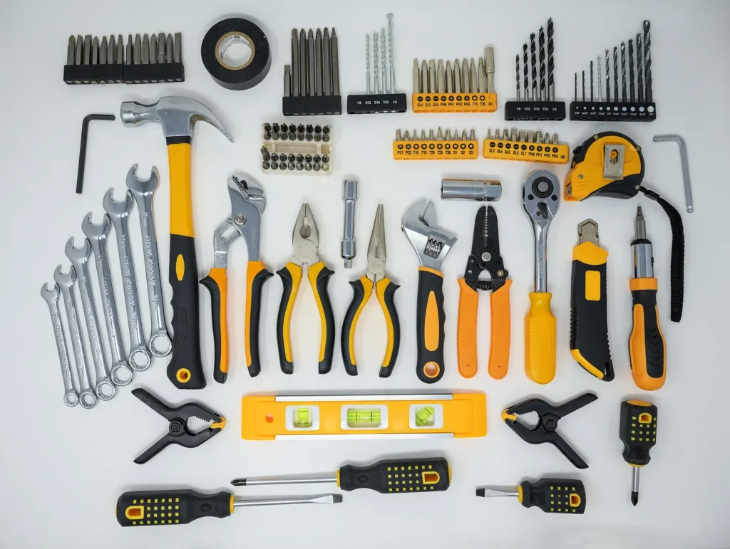 Kit de ferramentas manuais, bits e brocas dispostos sobre fundo branco
