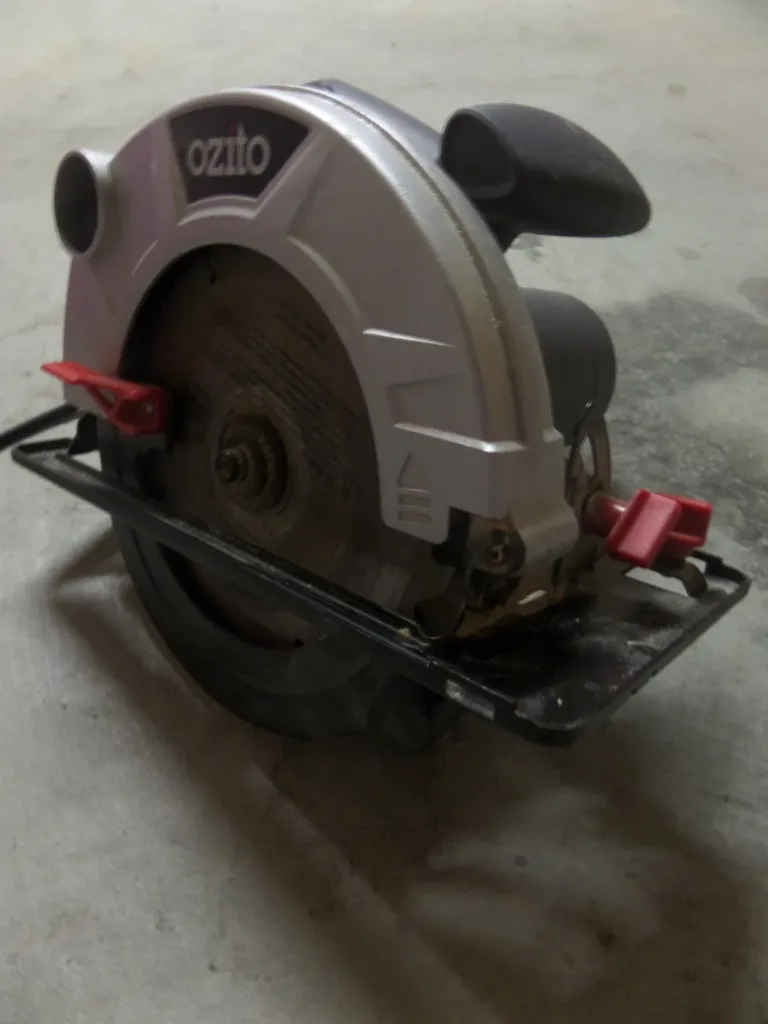 Serra tico-tico, esmerilhadeira ou serra circular: qual comprar primeiro? Serra circular elétrica com disco e proteção articulada, apoiada no chão